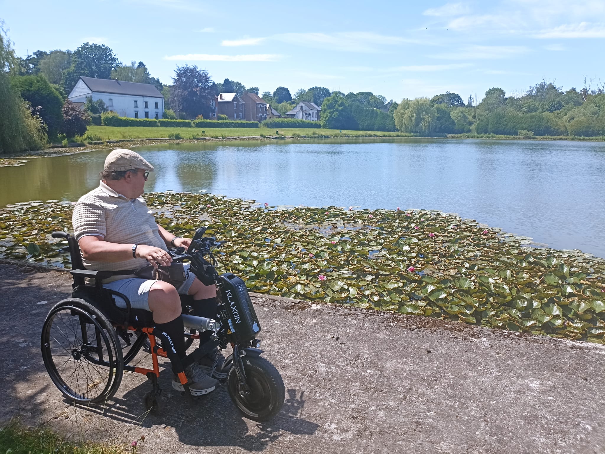 Dimitri avec son fauteuil et son aide à la mobilité
