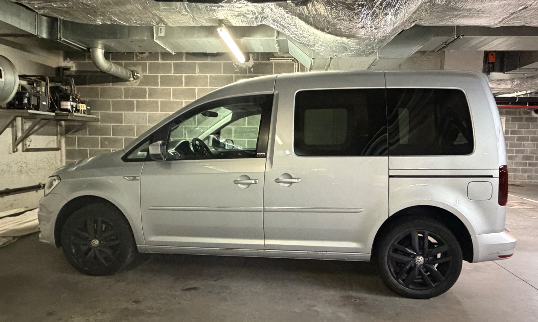 Volkswagen Caddy gris métallisé dans un parking